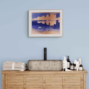 A minimalist bathroom setup with a wooden vanity, a concrete sink, and neatly arranged toiletries. A framed cityscape with a swan in front of it art piece hangs on a light blue wall.