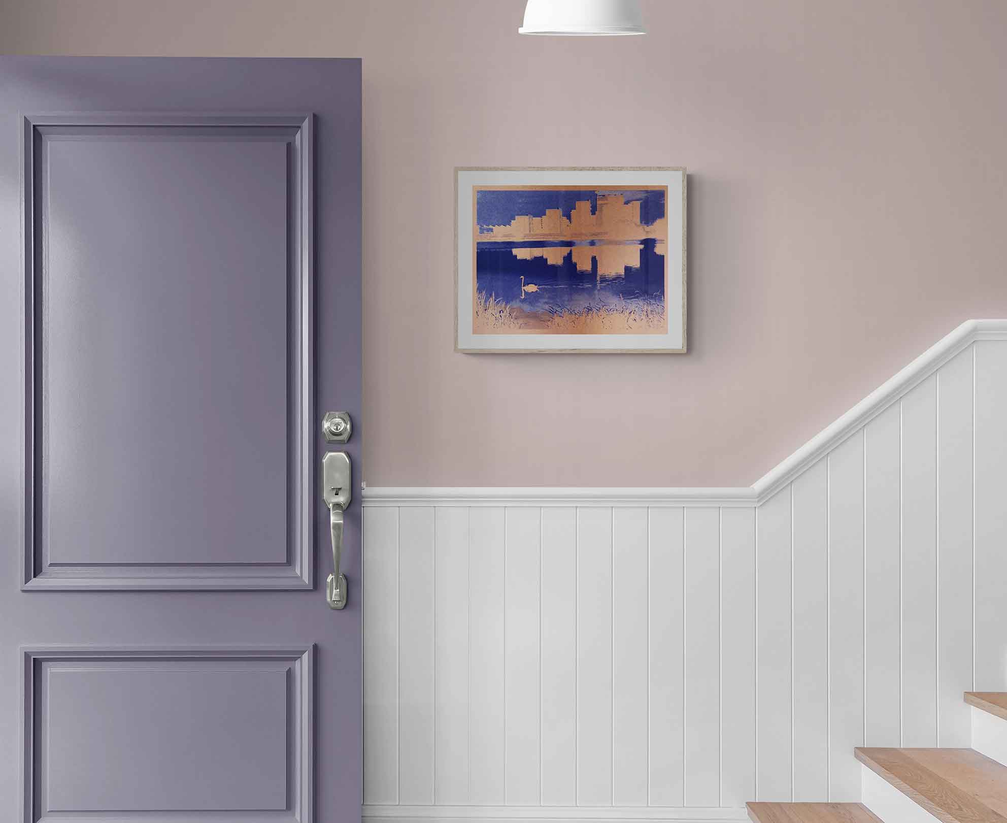 A purple door with a silver handle beside a staircase featuring wooden steps and white paneling. A purple and copper abstract print of a swan swimming at Walthamstow wetlands hangs on the wall.