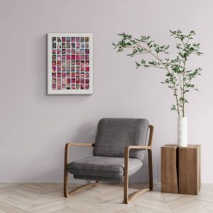 A minimalist room with a gray armchair, framed pink collage art on a light wall, and a vase with green branches on a wooden side table. Modern, calm ambiance.
